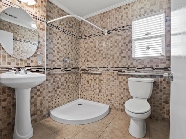 bathroom featuring tile walls, toilet, ornamental molding, a stall shower, and tile patterned flooring