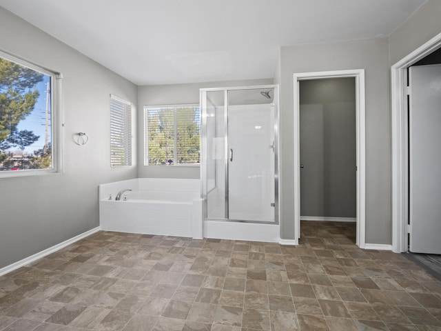 full bathroom with plenty of natural light, a shower stall, baseboards, and a garden tub