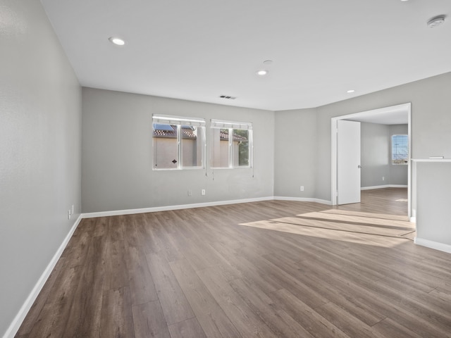 empty room with visible vents, baseboards, wood finished floors, and recessed lighting