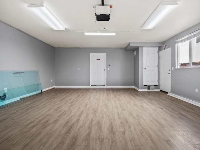 interior space featuring a garage door opener, visible vents, and baseboards