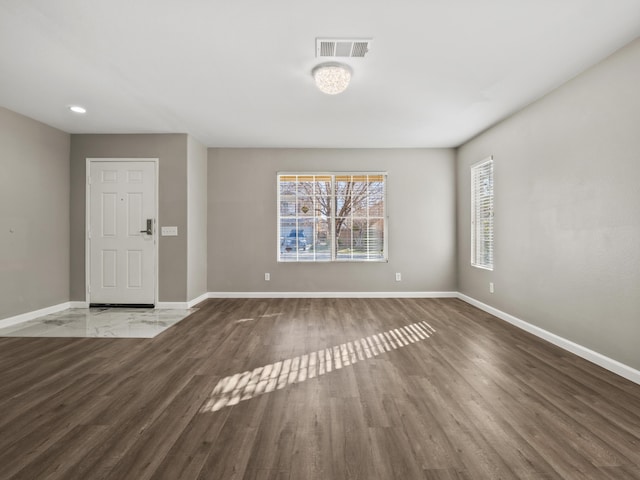 interior space with dark wood-style floors, visible vents, and baseboards