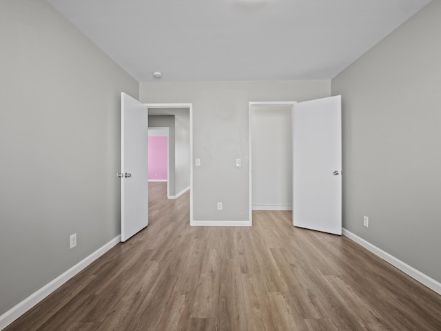 unfurnished bedroom featuring light wood-type flooring and baseboards