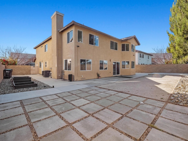 back of property featuring a patio area, central air condition unit, a fenced backyard, and stucco siding