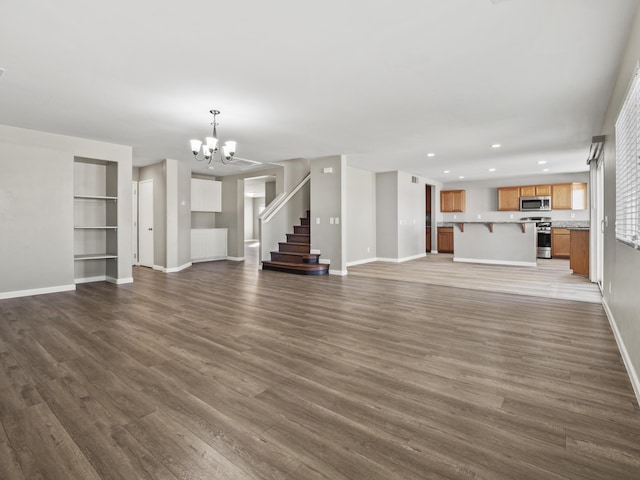 unfurnished living room with baseboards, dark wood-style floors, stairs, a chandelier, and recessed lighting