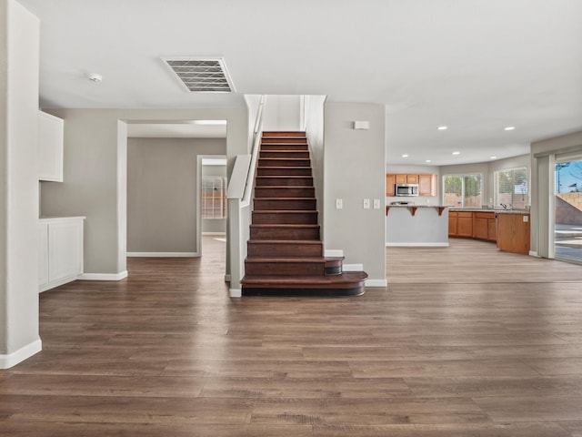 interior space featuring stairs, visible vents, baseboards, and wood finished floors