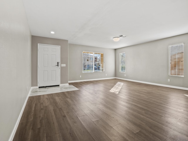 entrance foyer featuring dark wood-style flooring, visible vents, and baseboards