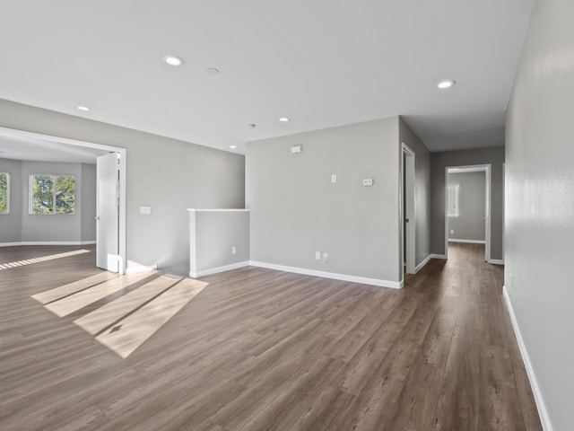 unfurnished room with dark wood-style flooring, recessed lighting, and baseboards