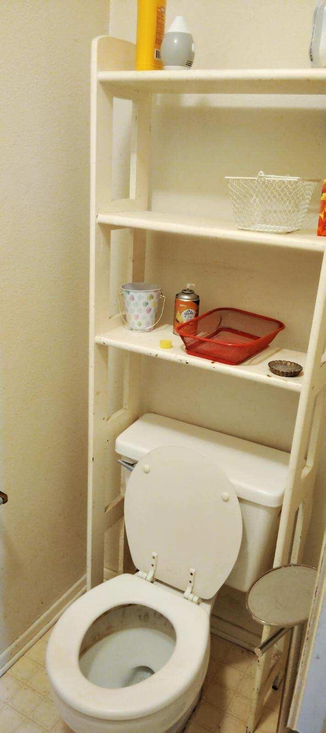 bathroom featuring toilet and baseboards