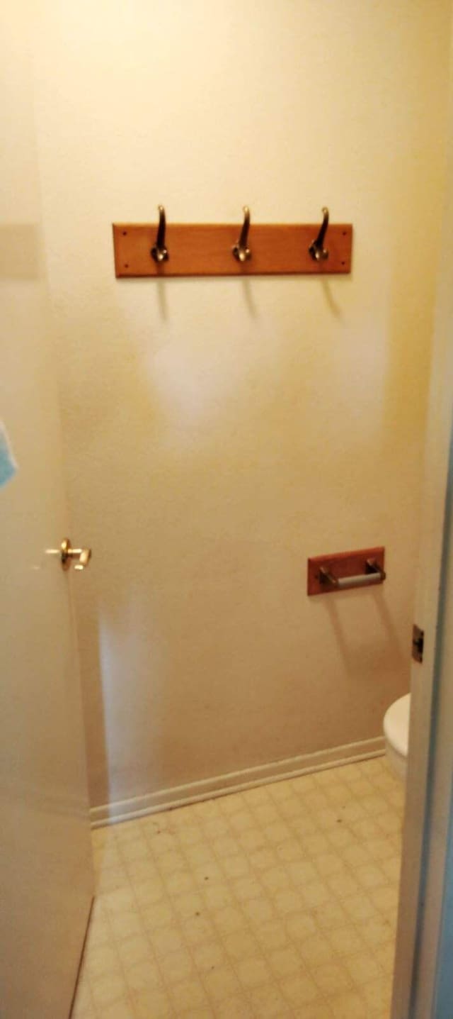 bathroom featuring baseboards, toilet, and tile patterned floors