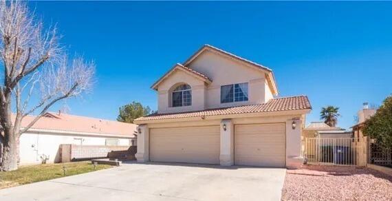 view of front of home featuring a garage, a tile roof, fence, concrete driveway, and stucco siding