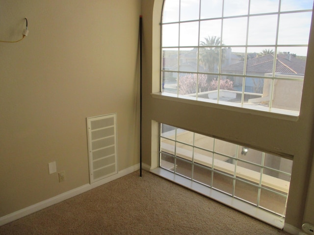 unfurnished room featuring baseboards, visible vents, and carpet