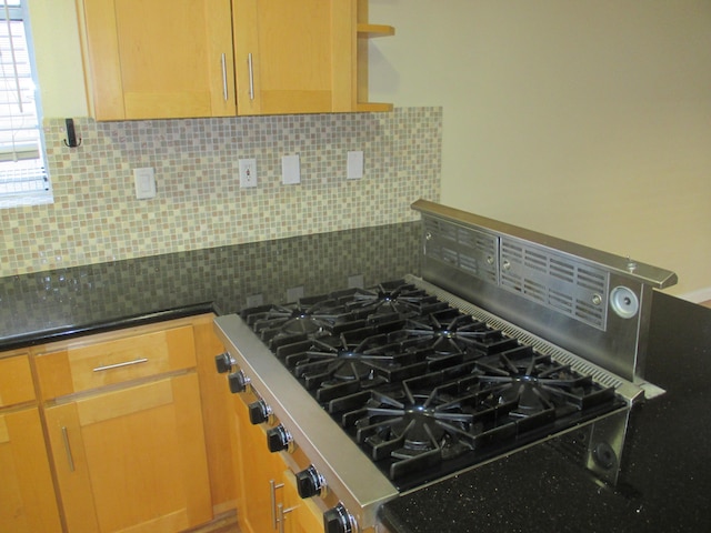 kitchen featuring dark stone counters and decorative backsplash