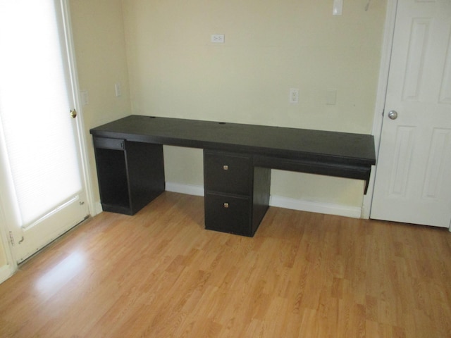 unfurnished office featuring built in study area and light wood-style floors
