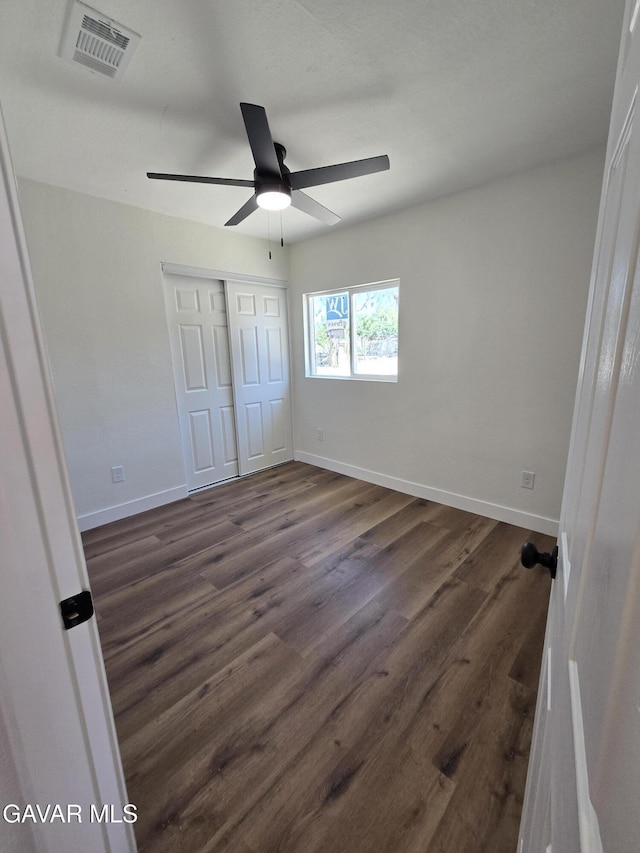 4102 Pearblossom Hwy, Palmdale, CA 93552 - unfurnished bedroom featuring dark wood-style flooring, a closet, and a ceiling fan
