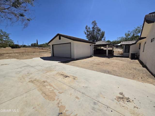 4102 Pearblossom Hwy, Palmdale, CA 93552 - view of side of property with an outbuilding, a garage, a tile roof, stucco siding, and driveway