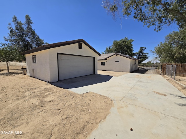 4102 Pearblossom Hwy, Palmdale, CA 93552 - view of side of home with stucco siding and a garage