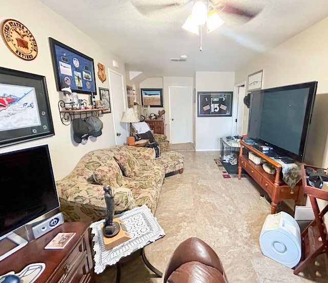 living room with ceiling fan and a textured ceiling