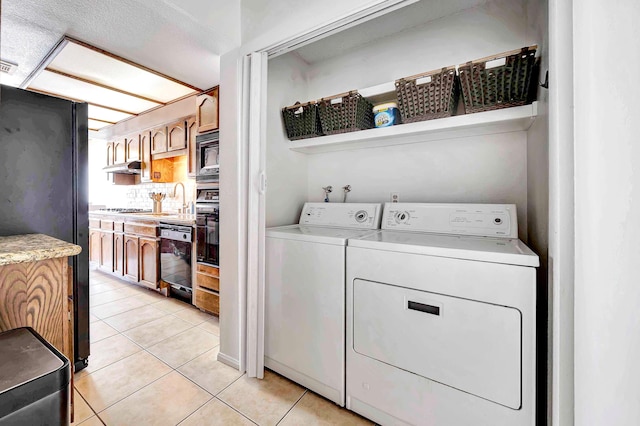 laundry area with light tile patterned floors, sink, and independent washer and dryer