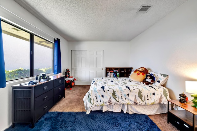 carpeted bedroom with a closet and a textured ceiling