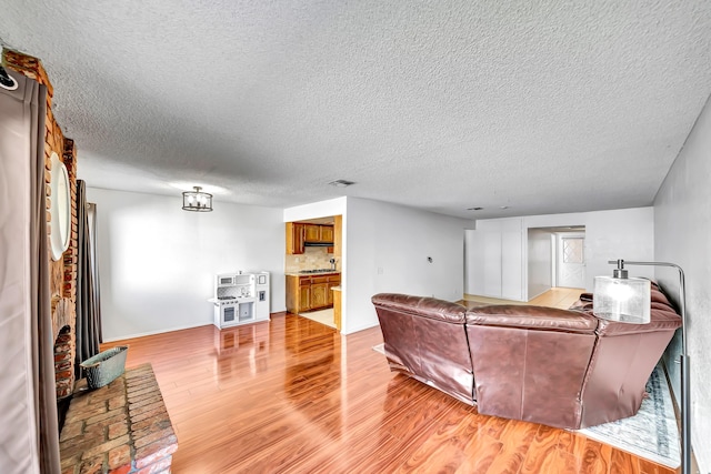 living room featuring a textured ceiling and light hardwood / wood-style flooring