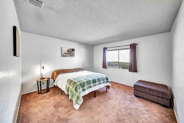 bedroom with carpet floors and a textured ceiling