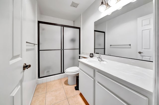 bathroom featuring vanity, toilet, tile patterned flooring, and a shower with door