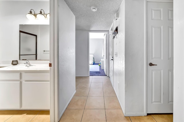 bathroom with a textured ceiling, tile patterned floors, and vanity