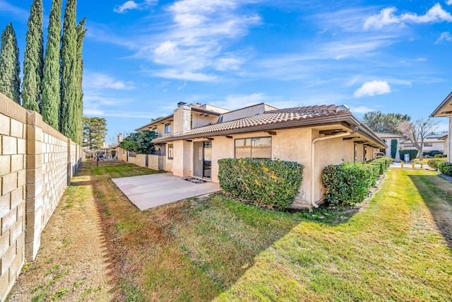 rear view of property with a yard and a patio