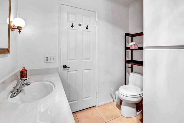 bathroom with toilet, vanity, and tile patterned floors