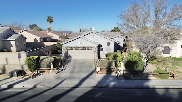 single story home featuring concrete driveway, a residential view, an attached garage, fence, and stucco siding