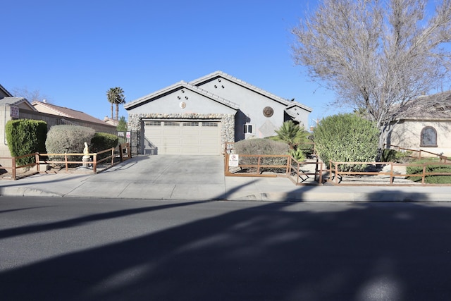 view of front of property with a garage, fence, driveway, and stucco siding