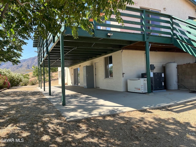 28714 Cruthers Creek Rd, Pearblossom, CA 93553 - rear view of house featuring stucco siding, a patio, a carport, and a deck with mountain view