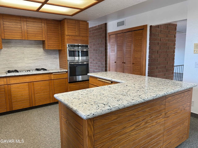 28714 Cruthers Creek Rd, Pearblossom, CA 93553 - kitchen with stainless steel double oven, brown cabinetry, light carpet, decorative backsplash, and gas cooktop
