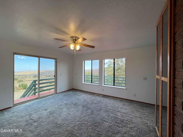 28714 Cruthers Creek Rd, Pearblossom, CA 93553 - carpeted empty room featuring plenty of natural light, a textured ceiling, and ceiling fan