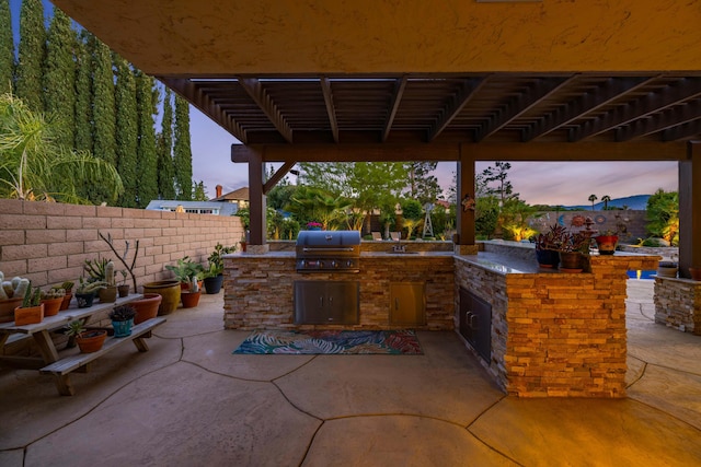436 Fairway Dr, Palmdale, CA 93551 - patio terrace at dusk featuring area for grilling, an outdoor kitchen, and fence
