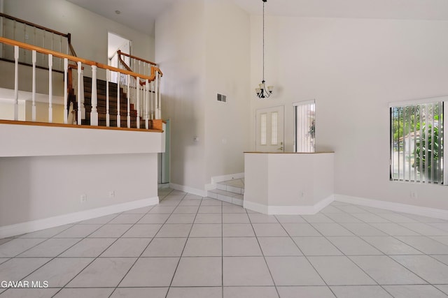 38100 San Mateo Ave, Palmdale, CA 93551 - unfurnished living room with tile patterned flooring, a high ceiling, and stairs