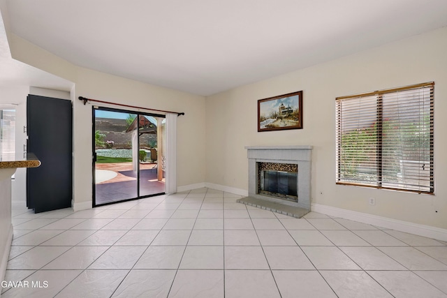 38100 San Mateo Ave, Palmdale, CA 93551 - unfurnished living room featuring light tile patterned floors and a glass covered fireplace