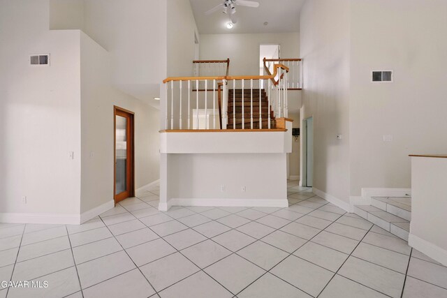 38100 San Mateo Ave, Palmdale, CA 93551 - unfurnished living room with a ceiling fan, a towering ceiling, tile patterned floors, and stairway