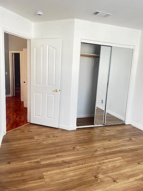 unfurnished bedroom with a closet and wood-type flooring