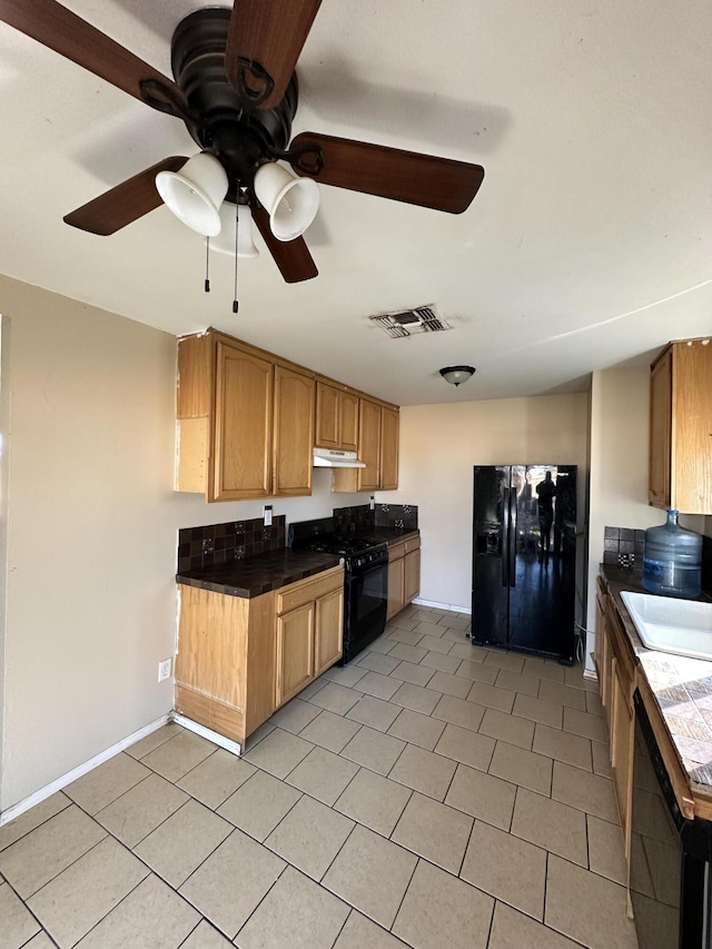 kitchen featuring ceiling fan, tile counters, sink, light tile patterned floors, and black appliances