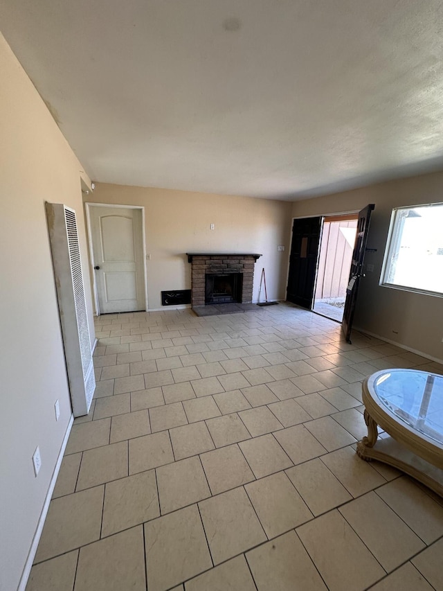 unfurnished living room with light tile patterned flooring and a brick fireplace