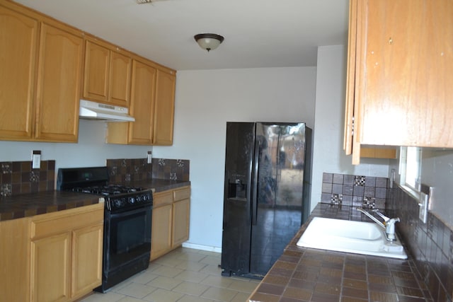 kitchen featuring light brown cabinetry, sink, tile countertops, and black appliances