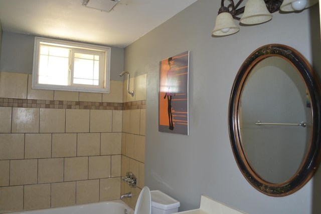 bathroom featuring tiled shower / bath and toilet