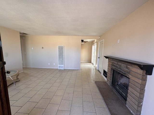 unfurnished living room with ceiling fan, light tile patterned floors, and a textured ceiling