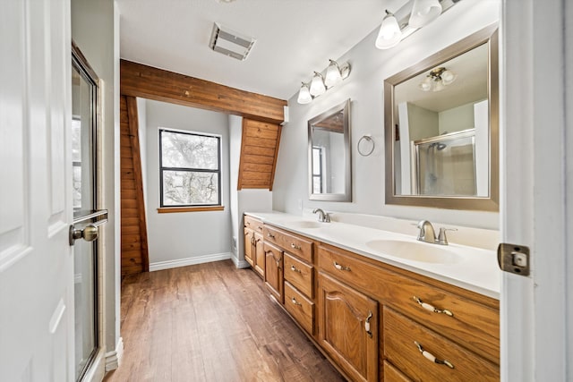 bathroom with beamed ceiling, vanity, a shower with door, and hardwood / wood-style floors