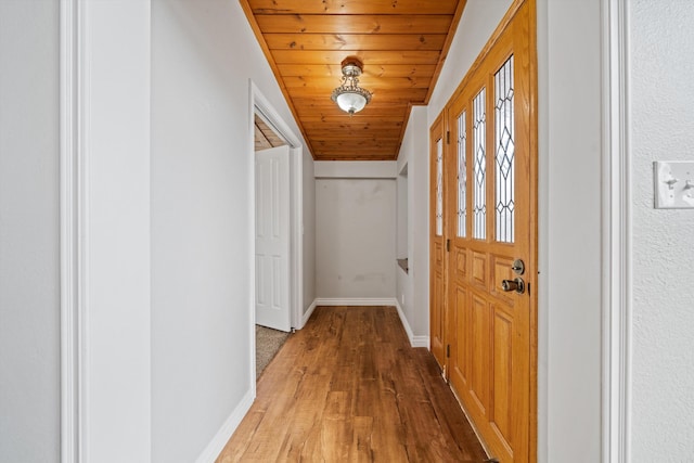 corridor featuring wood-type flooring and wooden ceiling