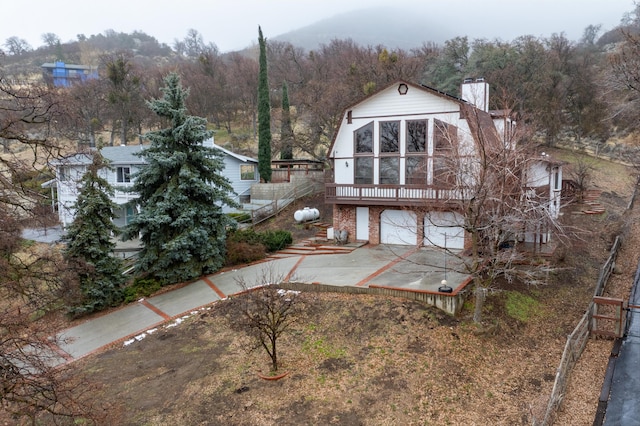 back of property with a wooden deck and a garage