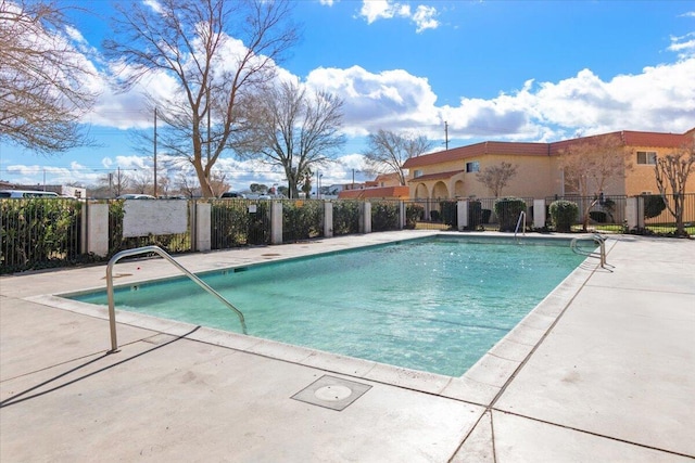 community pool with fence and a patio