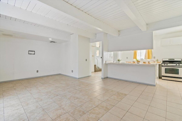 interior space with light tile patterned floors, beamed ceiling, visible vents, and baseboards