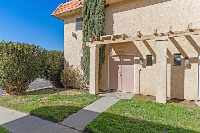 property entrance with a tiled roof and stucco siding